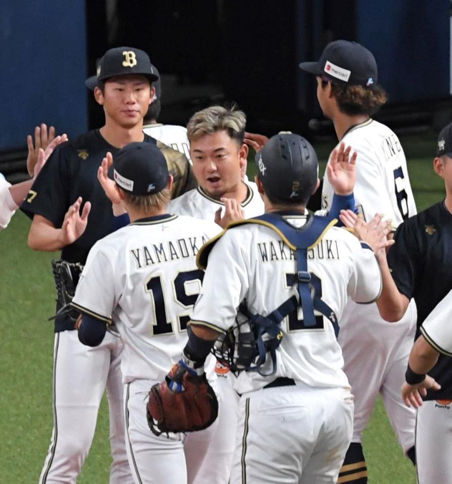 　チームが勝利し、最後を締めた山岡（１９）とタッチを交わす森（中央）＝撮影・北村雅宏