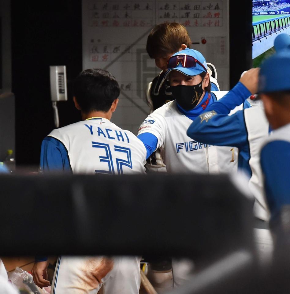 　２回、先制打を放ち、ベンチに戻った谷内（手前）と握手を交わす新庄監督（撮影・中島達哉）