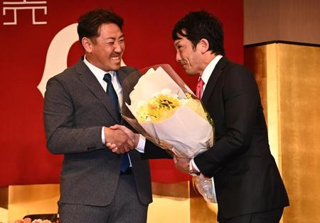 　引退会見で内川聖一氏（左）から花束を贈られ感極まる松田