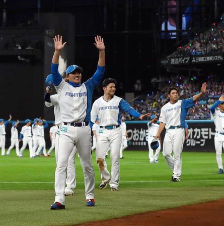 　場内一周しながらスタンドのファンに手を振る新庄監督（左）ら日本ハムナイン（撮影・中島達哉）