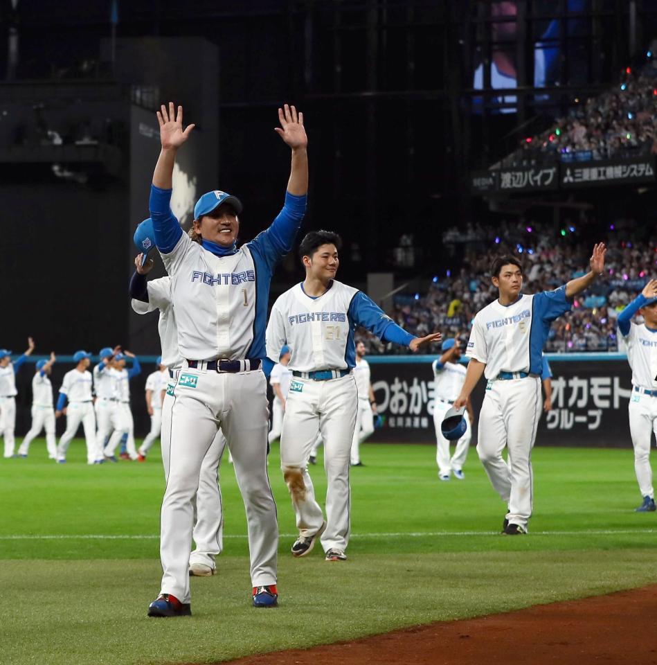 　場内一周しながらスタンドのファンに手を振る新庄監督（左）ら日本ハムナイン（撮影・中島達哉）