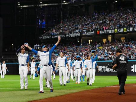 　場内一周しながらスタンドのファンに手を振る新庄監督（左）＝撮影・中島達哉