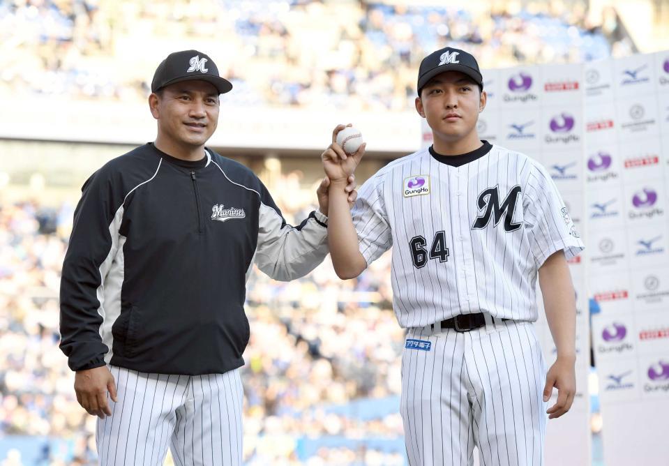 　プロ初勝利を挙げた佐藤奨（右）はウイニングボールを手に井口監督から祝福される＝２０２２年６月