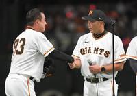 　阿部コーチ（右）とがっちりと握手を交わす原監督（撮影・佐藤厚）