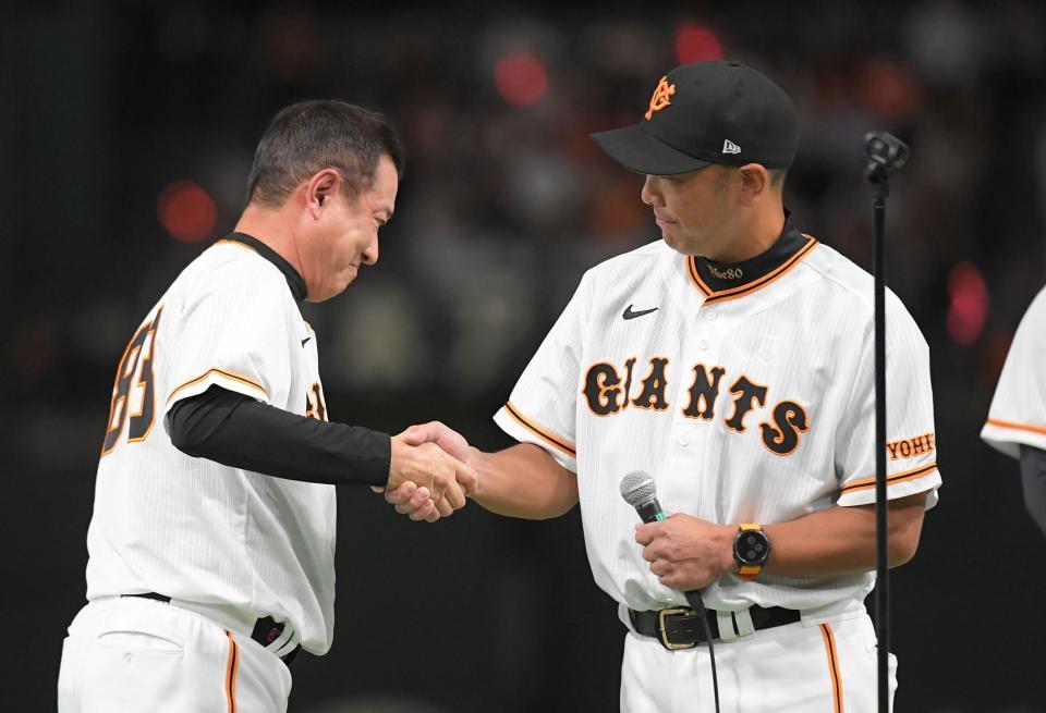 　阿部コーチ（右）とがっちりと握手を交わす原監督（撮影・佐藤厚）