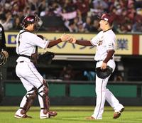 　太田（左）とタッチする３９セーブ目を挙げた松井裕（撮影・佐々木彰尚）