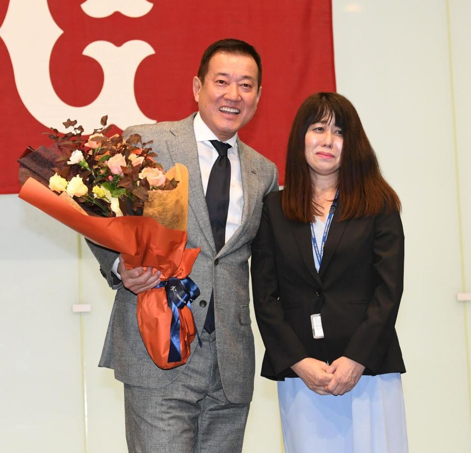 　球団職員の水澤美由紀さん（右）から花束を贈られ笑顔を見せる原監督（撮影・佐藤厚）