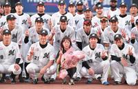 　試合後のセレモニーで吉井監督（前列左から２人目）らナインと記念撮影に納まるアナウンス担当・谷保恵美さん（前列中央）＝撮影・開出牧