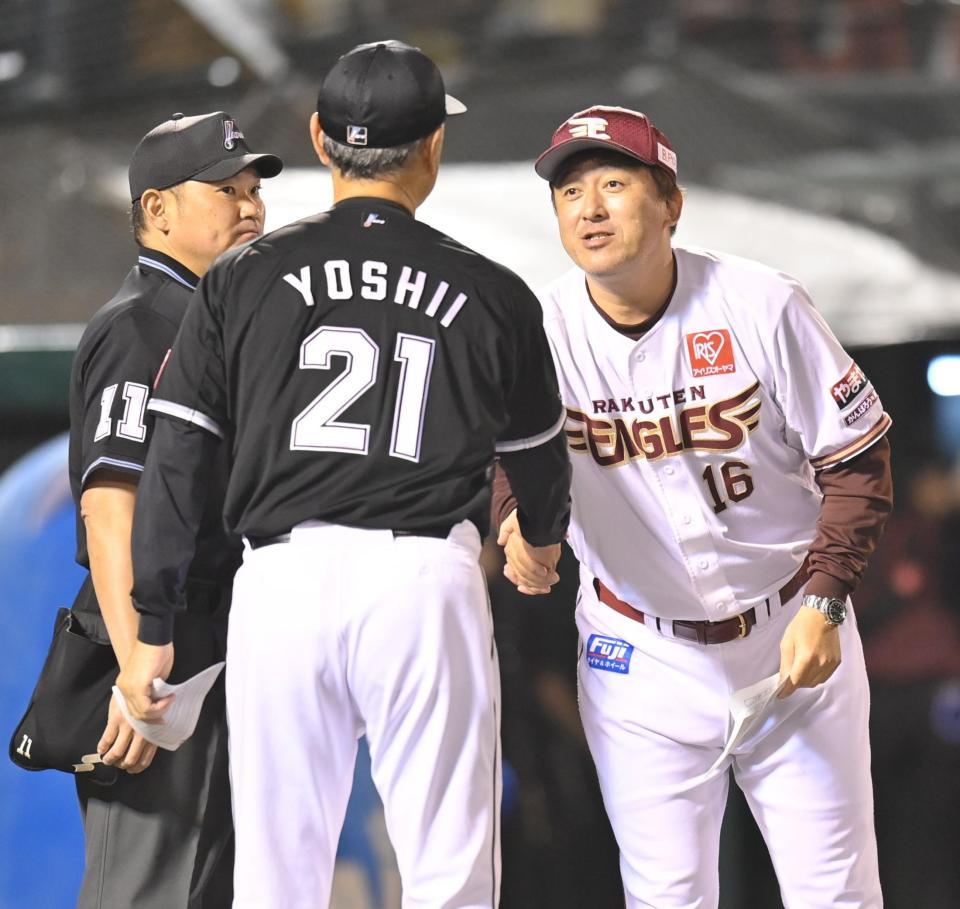 　メンバー表交換で吉井監督（左）と握手を交わす石井監督（撮影・西岡正）