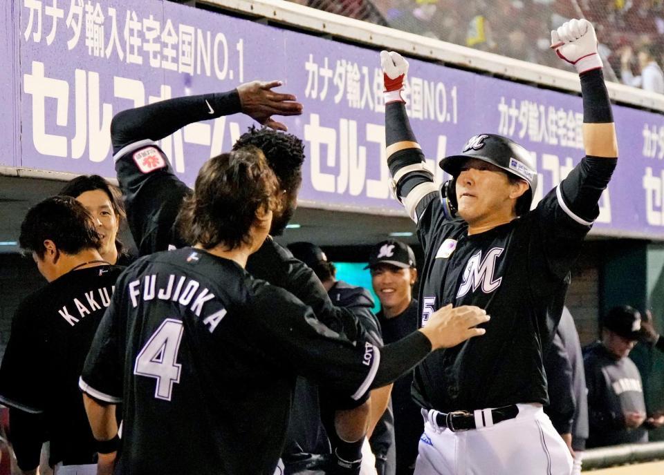 　４回、本塁打を放ち、ナインに迎えられる安田（右）