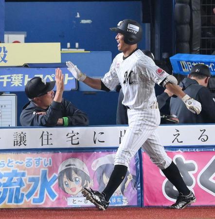 　１回、先頭打者本塁打を放ち、吉井監督（左）に迎えられる荻野（撮影・伊藤笙子）