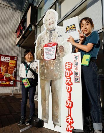 　カーネル・サンダース人形の等身大パネルと記念撮影する阪神ファンの女の子たち＝１６日午後、兵庫県西宮市