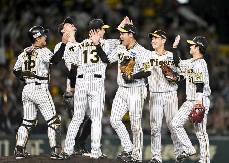 　広島に３連勝して日本シリーズ進出を決め、タッチを交わす阪神ナイン＝甲子園