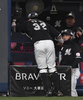 　１回、宗の邪飛を、ベンチ内をのぞき込むように捕球した佐藤都（撮影・北村雅宏）