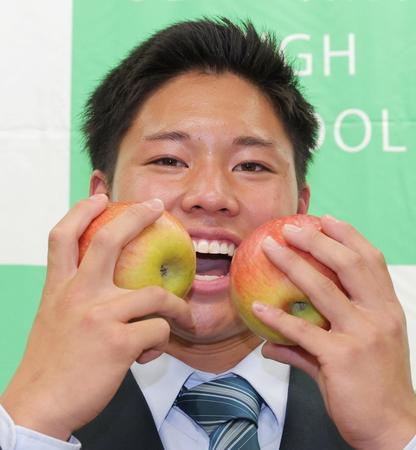　オリックスから１位指名を受け、信州産のリンゴを手に笑顔を見せる上田西の横山聖哉