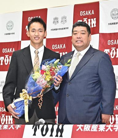 　ソフトバンクから１位指名され、花束を手に笑顔の西谷浩一監督（右）と大阪桐蔭・前田悠伍