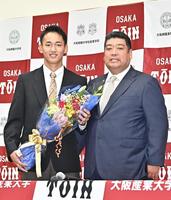 　ソフトバンクから１位指名され、花束を手に笑顔の西谷浩一監督（右）と大阪桐蔭・前田悠伍