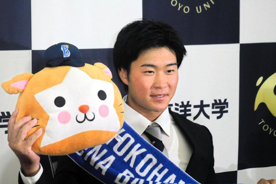 　ＤｅＮＡに４位指名され、スターマンを手にほほえむ東洋大・石上泰輝（撮影・広川　継）