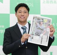 　オリックスから１位指名を受け、新聞委員会が発行した号外を手に笑顔を見せる上田西の横山聖哉