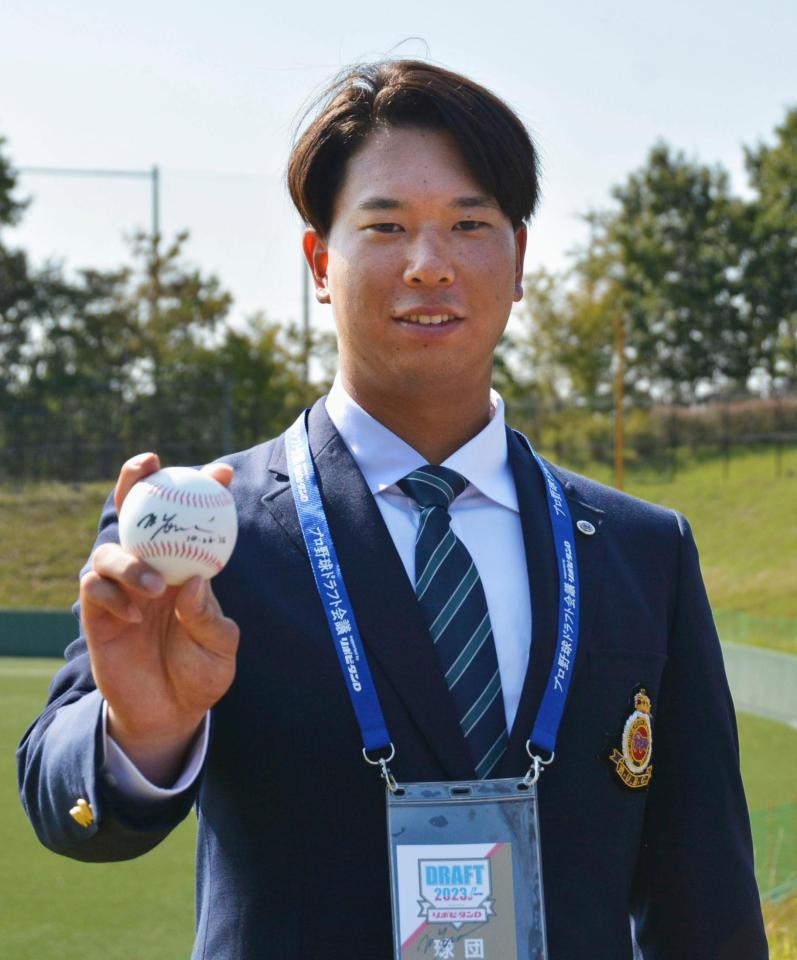 　ロッテからドラフト１位指名のあいさつを受け、ポーズをとる明大・上田