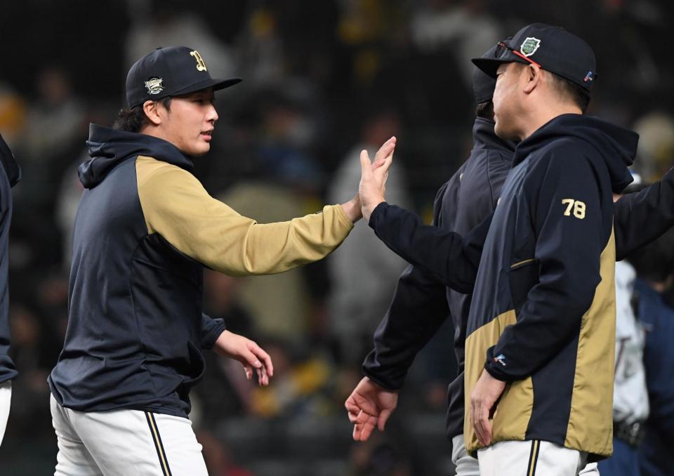 　中嶋監督（右）とタッチを交わす東（撮影・中田匡峻）