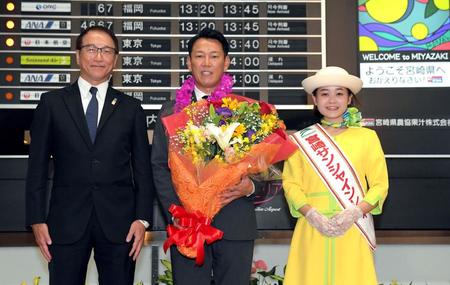　宮崎市観光協会・永山博康副会長（左）と宮崎サンシャインレディーから歓迎される侍ジャパン・井端監督（撮影・佐藤厚）