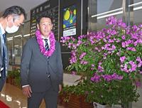 　宮崎空港に到着し、ブーゲンビリアの花の前を通る井端監督