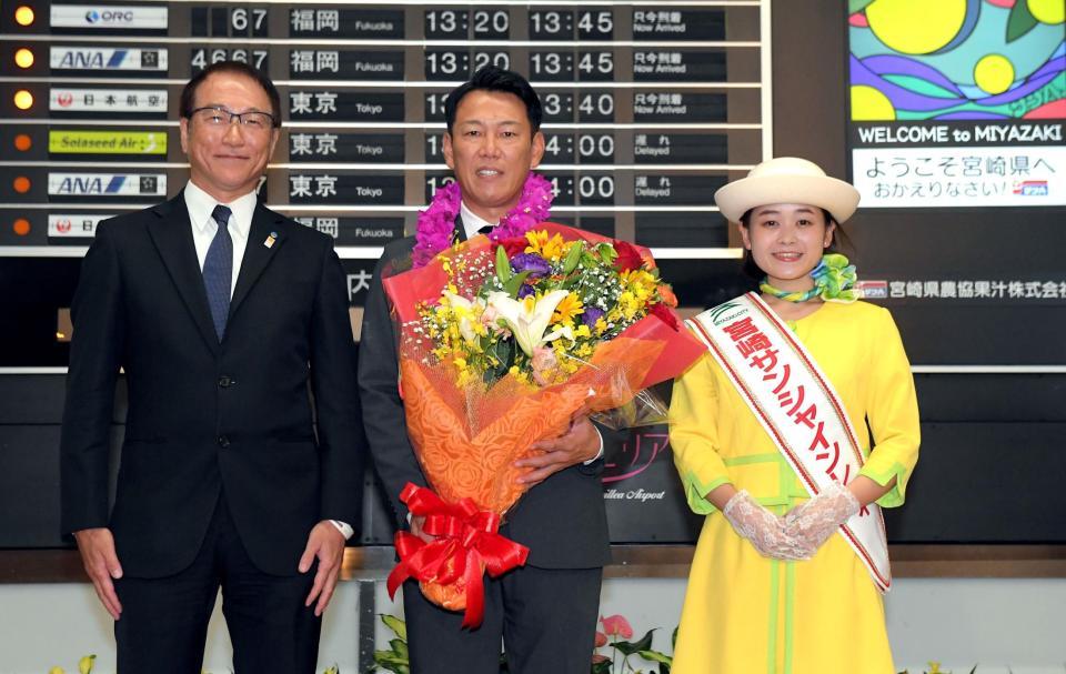 　宮崎市観光協会・永山博康副会長（左）と宮崎サンシャインレディーから歓迎される侍ジャパン・井端監督（撮影・佐藤厚）