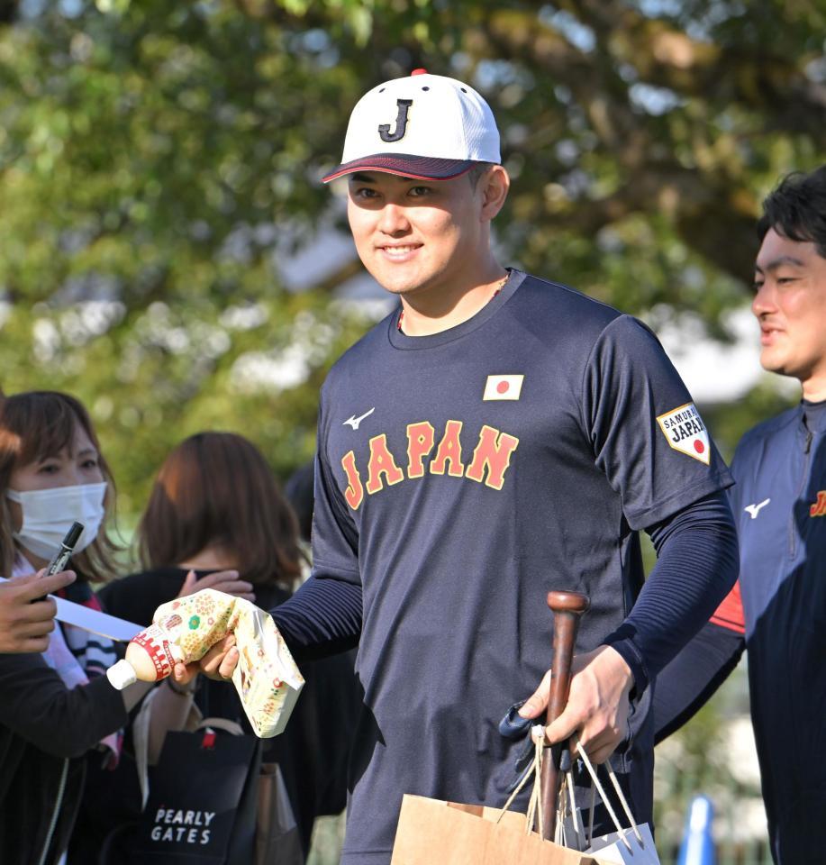 　ファンからの差し入れを手に笑顔で引き揚げる野口