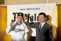 　仮契約を終え、福良ＧＭ（右）に帽子をかぶせてもらった堀