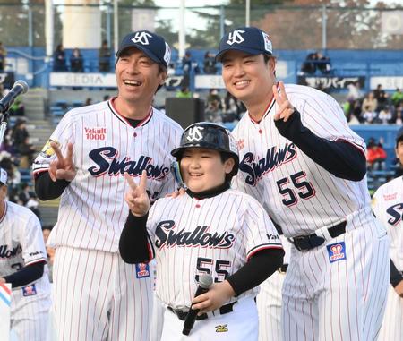 　自身のそっくりなファンの子供と記念撮影をする村上。左は高津監督（撮影・堀内翔）