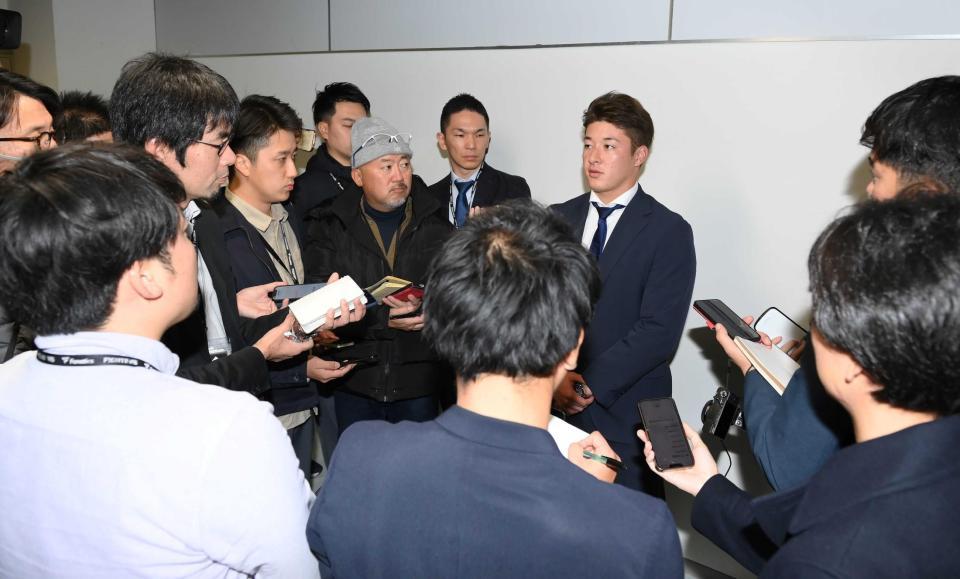 　報道陣の取材に答える吉田（中央）