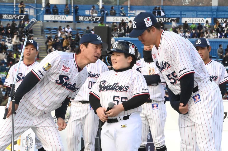 　村上（右）にそっくりなファンの子供に耳打ちをする高津監督（左）＝撮影・堀内翔