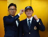 　仮契約を結び、橿渕スカウトデスクに帽子をかぶせてもらう明大・石原（撮影・高石航平）