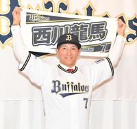　自身のグッズを掲げる西川（撮影・石井剣太郎）