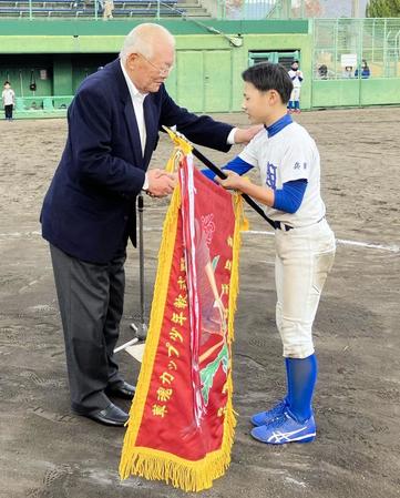 　優勝旗を手渡し、握手する鈴木啓示さん（左）