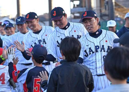 　野球少年たちをタッチで見送る侍ジャパンの（手前から）井端監督、金子ヘッドコーチ、吉見投手コーチ（撮影・三好信也）