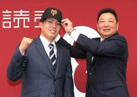 　吉村編成本部長（右）から帽子をかぶせてもらう馬場（撮影・佐藤厚）