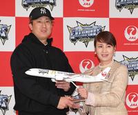 　飛行機の模型を日本航空職員より受け取る杉本（左）＝撮影・北村雅宏