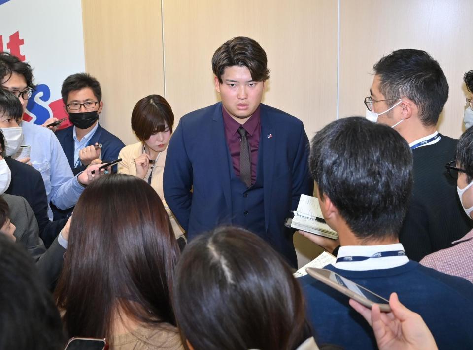 　契約更改を終えて報道陣の質問に答える村上（中央）＝撮影・西岡正