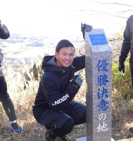 　恒例の山登りトレを行い、頂上の石碑にサインを書き込む山崎