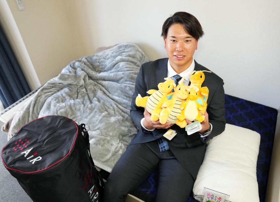 　似ているといわれるポケモンの“カイリュー”のぬいぐるみを抱いて笑顔の上田