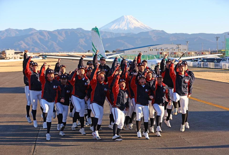 　選抜高校野球大会出場が決まり、富士山と飛行機をバックに喜ぶ日本航空石川の選手たち