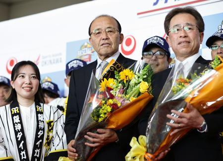 　那覇空港に到着し、歓迎セレモニーで花束を手に記念撮影する阪神・岡田監督（中央）＝３１日