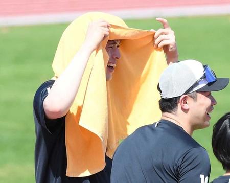 　日焼け防止のためタオルを頭から被りナインと談笑する佐々木朗
