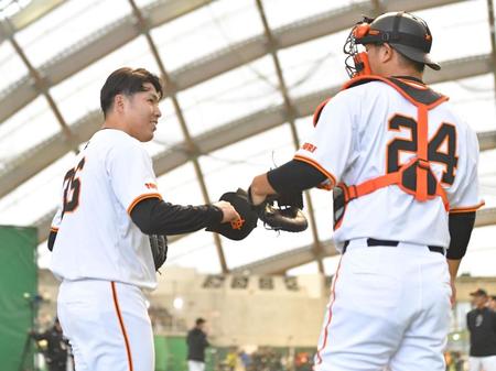 　ブルペン投球を終え、大城（右）とタッチを交わす馬場（撮影・西岡正）