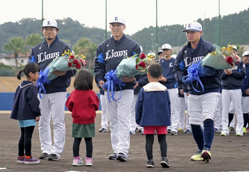 　キャンプインし、練習開始前に花束を受け取る松井監督（中央）ら＝南郷