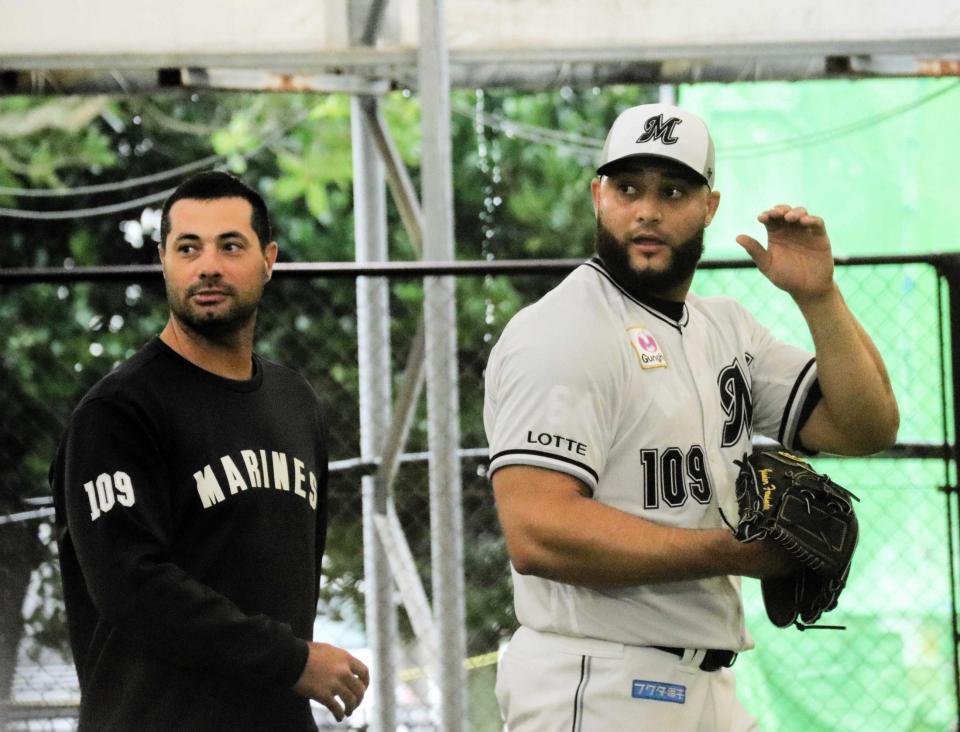 　「１０９」のユニホームを着てブルペン入りしたフェルナンデス（右）とフェルナンデス通訳兼打撃投手