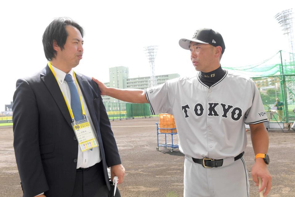 　激励に訪れた本紙評論家・井川氏（左）の左腕を触る阿部監督（撮影・佐藤厚）