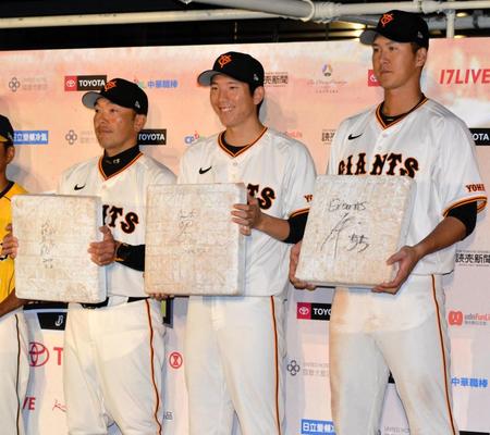 　試合後、会見で使用したベースにサインを書いた（左から）阿部監督、戸郷、秋広